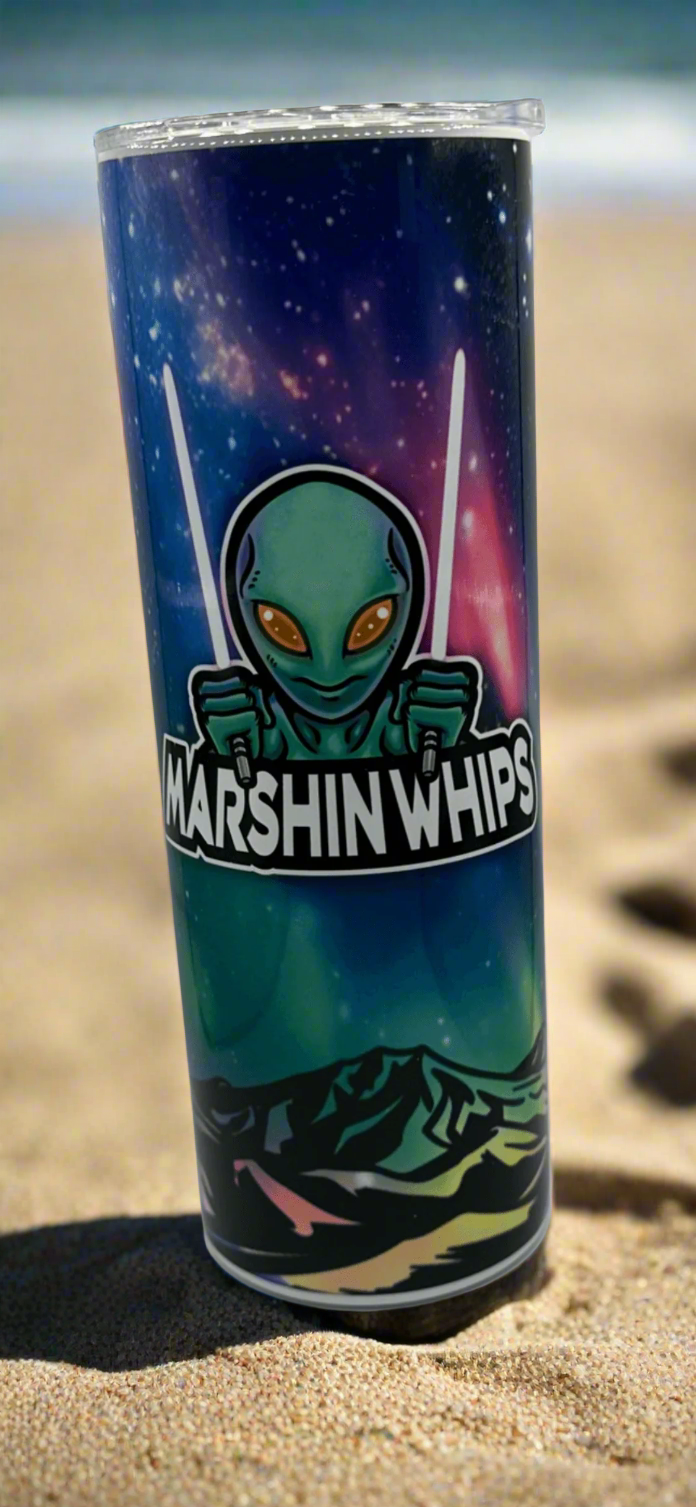 Tumbler with alien design and 'Marshin Whips' branding on the beach in the sand