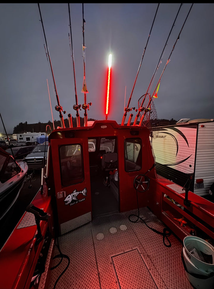 Red fishing boat interior with a lit red light against a dark sky.