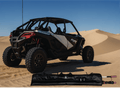 Off-road vehicle on sand dunes with a folded canopy in the foreground