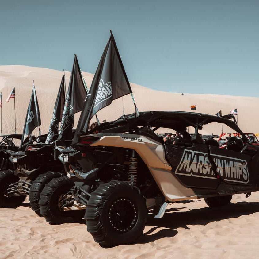 Row of off-road vehicles with 'MARS SNOWPUP' branding on sand dunes.