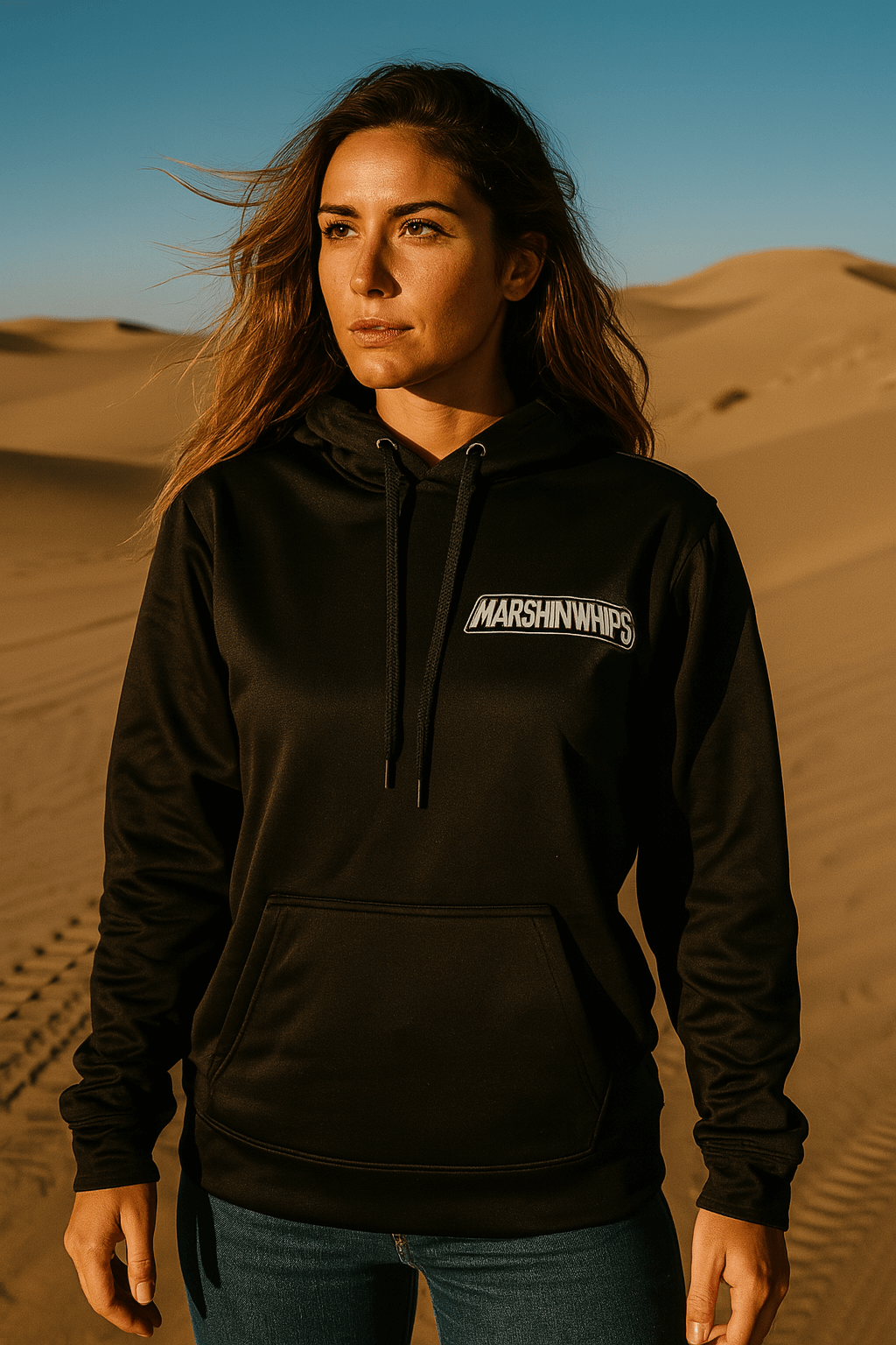 Person wearing a black Marshin Whips hoodie with a logo in a desert setting