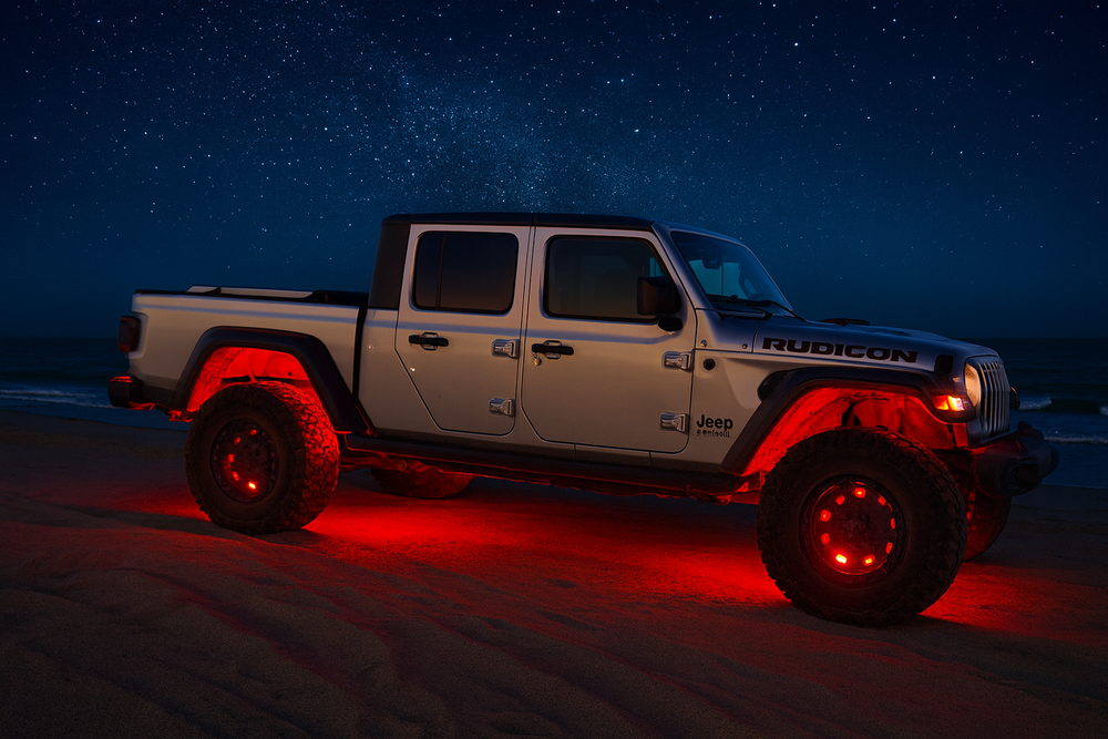 Jeep Gladiator truck on a beach at night with red underglow lights