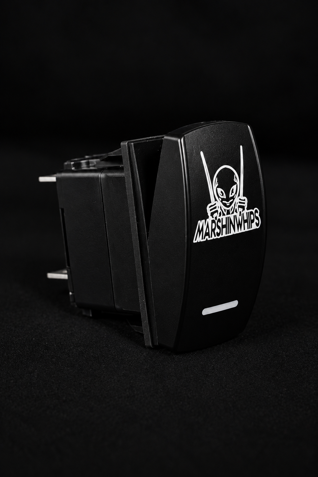 A black Marshin Whips toggle switch with a molded faceplate featuring a white alien laser engraved graphics
