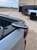 A black and silver Marshin Whips metal truck bed accessory with mounting holes for led whips, shown resting on the tailgate 