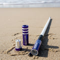 Purple Game Changer Whip on a sandy beach with ocean waves in the background