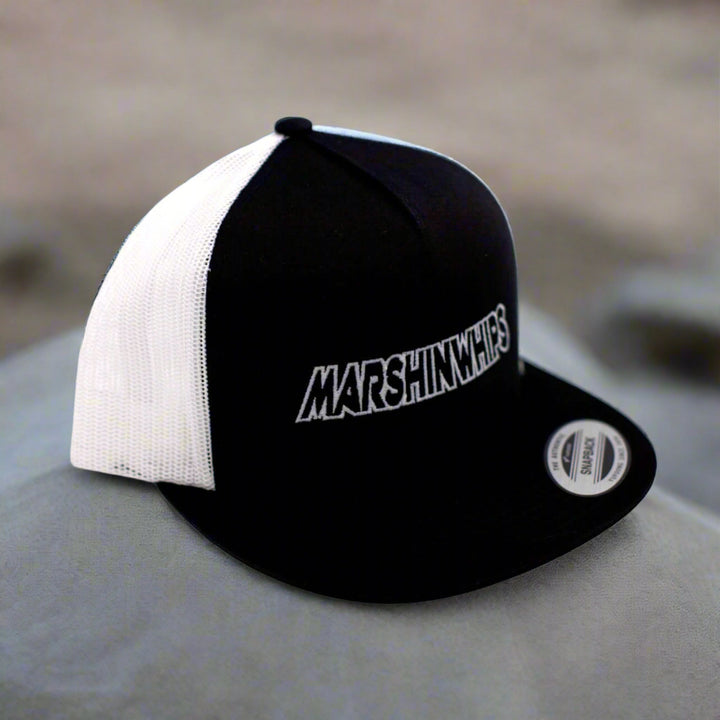 Black and white cap with 'MARSHIN WHIPS' logo on a blurred background