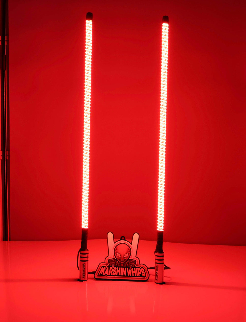 Two illuminated LED lightsabers on a red background with a Marshin Whips product below.